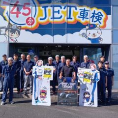 静岡支店の前で等身大パネルとポスターを持つスタッフ一同